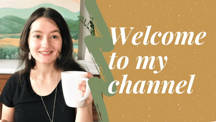 Picture of me holding a mug, I'm wearing a black shirt and am smiling brightly at the camera. The image has the words overlaid, "Welcome to my Youtube channel".